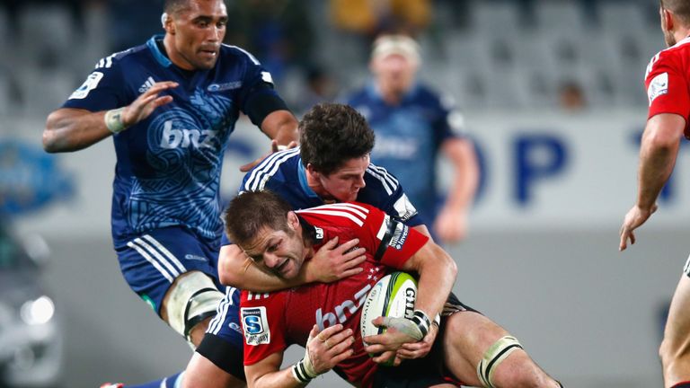  Richie McCaw of the Crusaders is tackled by Simon Hickey of the Blues