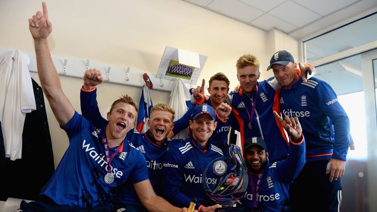 England captain Eoin Morgan (C) celebrates in the dressing room with team-mates
