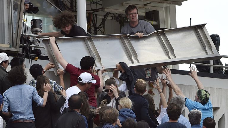 People remove a structure which fell from the Chatrier court during the match Japan's Kei Nishikori vs France's Jo-Wilfried Tsonga 