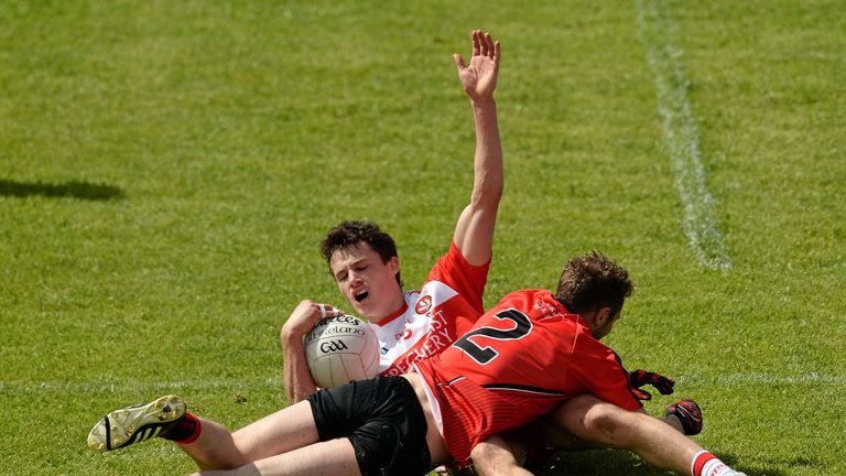 Derry wing-back Kevin Johnston is dragged down by Darren O'Hagan