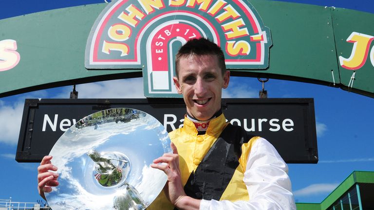 Winning jockey George Baker celebrates with the trophy after victory with Quest For More in the John Smith's Northumberland Plate during the John Smith's N