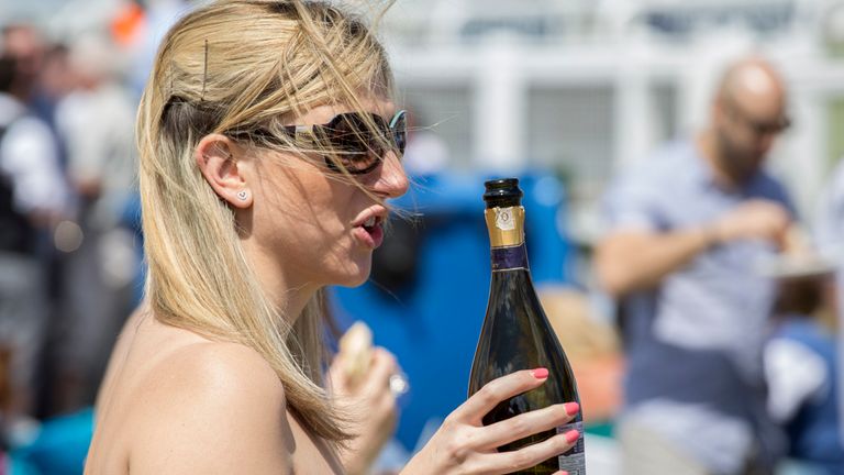 A racegoer enjoys a drink