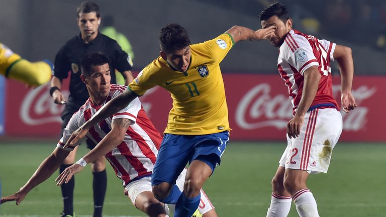 Brazil's forward Roberto Firmino (C) is marked by Paraguay's midfielders Victor Caceres (L) and Eduardo Aranda during their 2015 Copa America