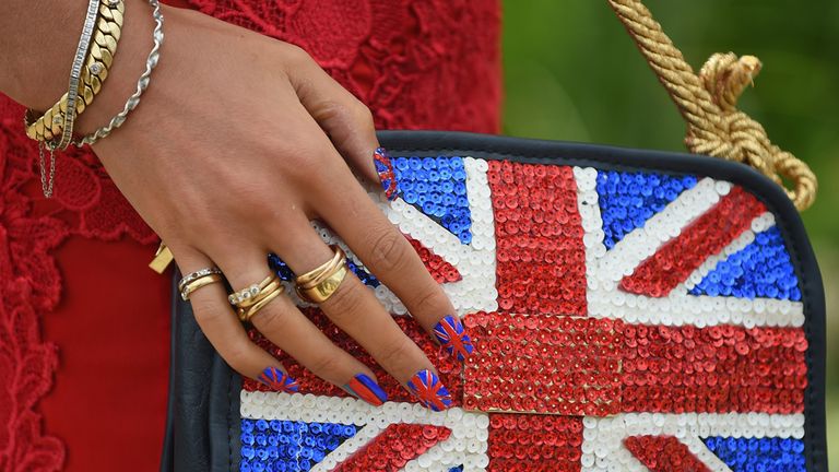 A racegoer shows off her matching finger nails and handbag at Royal Ascot