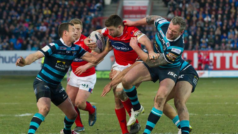 Hull KR's Darrell Goulding is wrapped up by Leeds duo Danny McGuire and Jamie Peacock