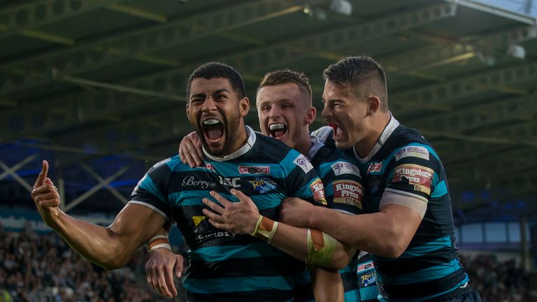 Leeds's Kallum Watkins is congratulated on scoring against Hull FC by Ash Handley and Stevie Ward