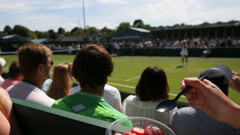 A spectator eating strawberries and cream during day one of the Wimbledon Championships at the All England Lawn Tennis and Croquet Club, Wimbledon.