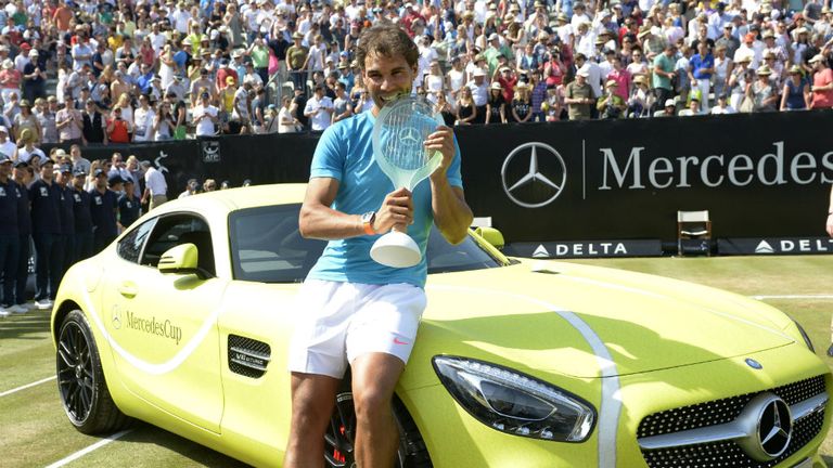 Rafael Nadal poses with a Mercedes with the trophy after defeating Viktor Troicki in the Stuttgart final