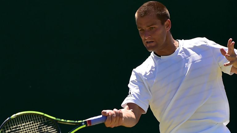 Mikhail Youzhny returns against Benoit Paire at Wimbledon