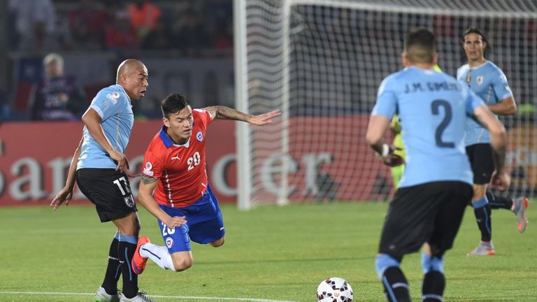 Uruguay's midfielder Egidio Arevalo Rios (L) vies for the ball with Chile's midfielder Charles Aranguiz 