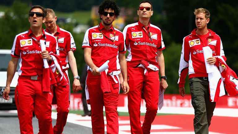 Sebastian Vettel of Ferrari walks the Austrian GP track with members of his team 