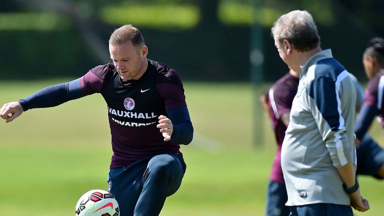 England's manager Roy Hodgson (R) looks on as England's striker Wayne Rooney takes part in a team training 