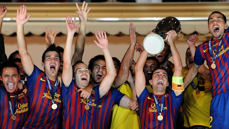Xavi Hernandez of FC Barcelona holds the trophy aloft amid his team-mates Alexis Sanchez, David Villa and Andres Iniesta - UEFA Super Cup v Porto in 2011