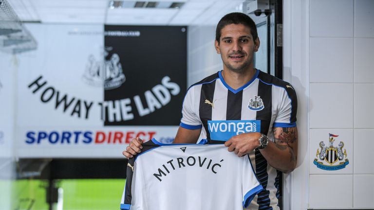 Aleksandar Mitrovic holds a Newcastle United shirt in the tunnel at St James' Park after signing for the club