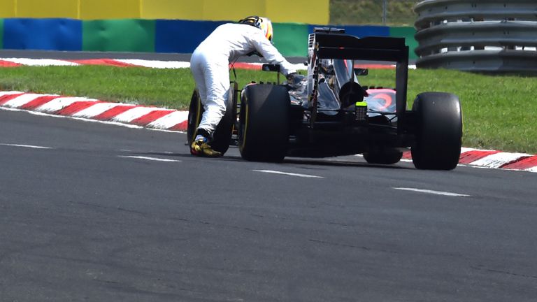 Fernando Alonso pushes his McLaren car during qualifying