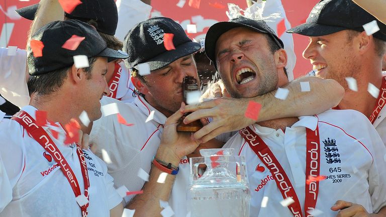 England player Graeme Swann (2/L) kisses the Ashes trophy as captain Andrew Strauss (L), Jonathan Trott (2/R) and Andrew Flintoff (R)