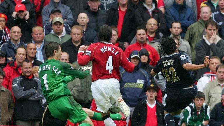 Carlos Tevez sneaks the ball under Edwin van der Sar at Old Trafford