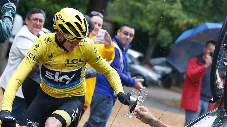 Britain's Chris Froome, wearing the overall leader's yellow jersey, toasts with his team manager during the 21st and last stage of the Tour de Fran