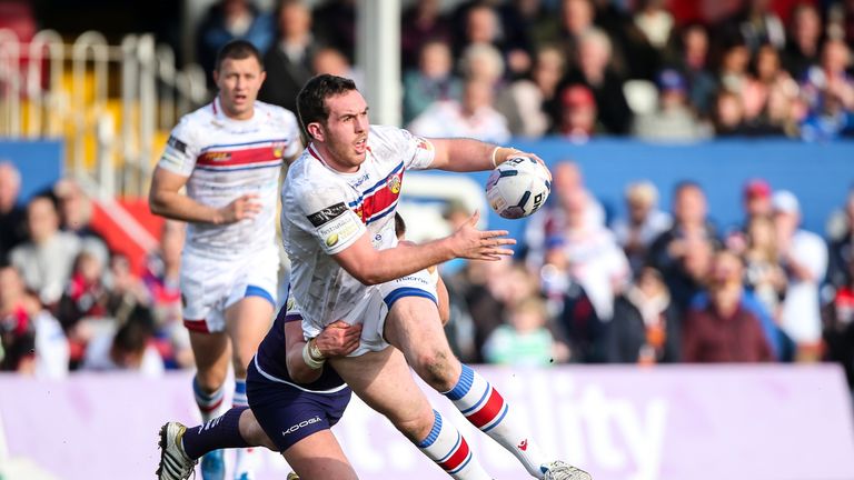 Wakefield's Daniel Smith is tackled by Huddersfield's Josh Johnson.
