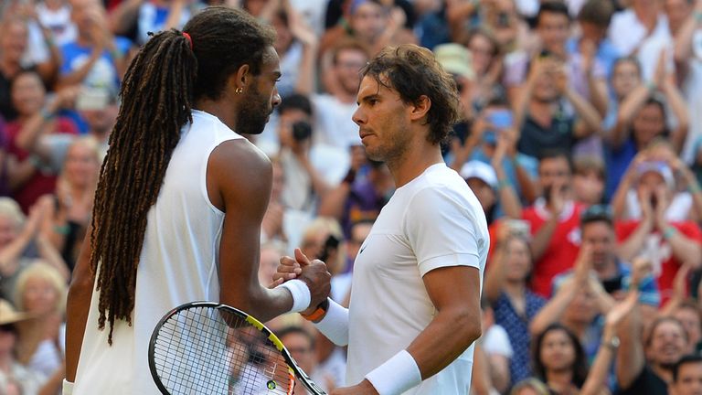 Germany's Dustin Brown (L) shakes hands with Spain's Rafael Nadal (R) after winning their men's singles second round match on day four of Wimbledon