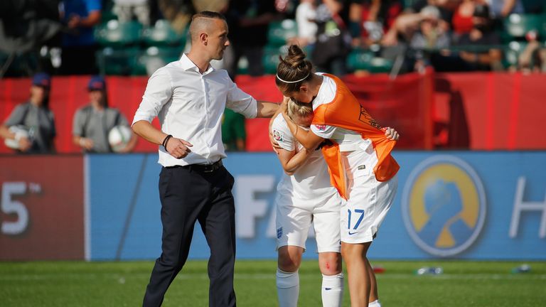 Laura Bassett of England is comforted by Jo Potter and England manager Mark Sampson after the FIFA Women's World Cup Semi Final match v Japan