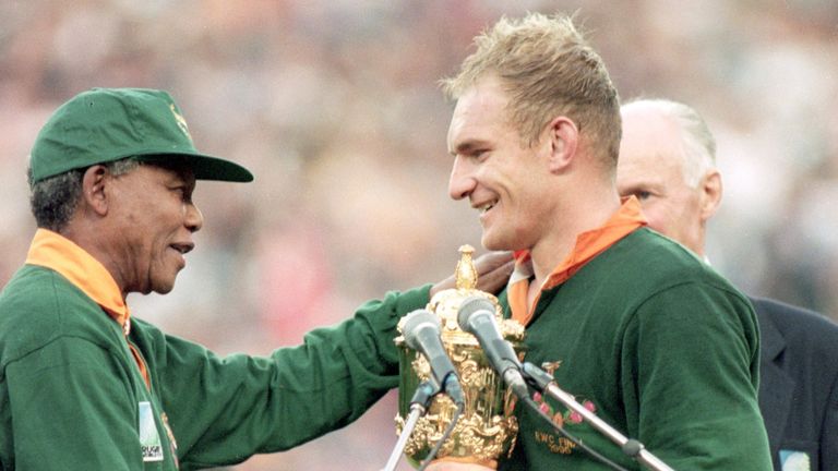 Francois Pienaar of South Africa receives the William Webb Ellis Trophy from President Nelson Mandela after the Rugby World Cup final