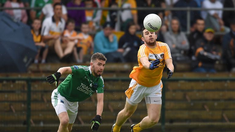 Antrim's Conor Murray gets his pass away despite the efforts of James McMahon of Fermanagh