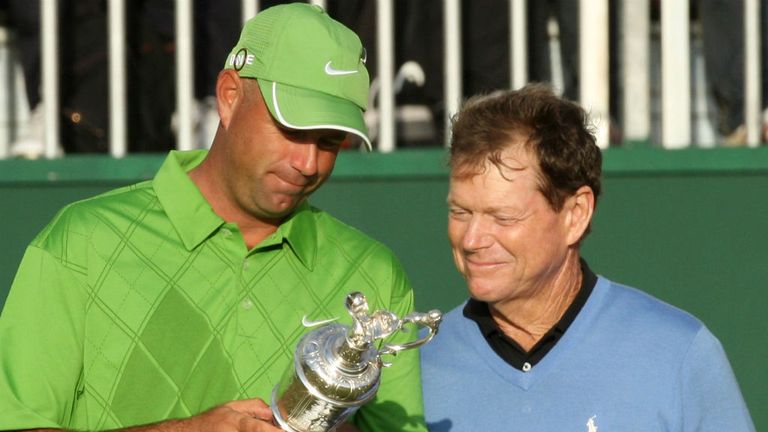 Stewart Cink (L) looks at the Claret Jug with Tom Watson after his victory in a play off in the 138th Open Championship at Turnberry Golf Club