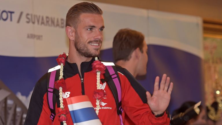 Liverpool football player Jordan Henderson waves to the media upon arriving at Suvarnabhumi International airport in Bangkok