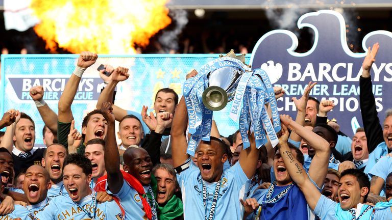 MANCHESTER, ENGLAND - MAY 13:  Vincent Kompany the captain of Manchester City lifts the trophy following the Barclays Premier League match between Manchest