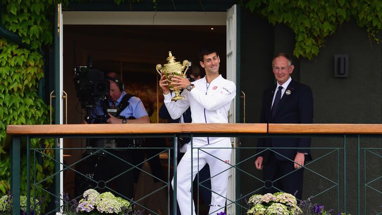 Novak Djokovic of Serbia celebrates with the trophy on the clubhouse balcony after winning the Final Of The Gentlemen's Singles