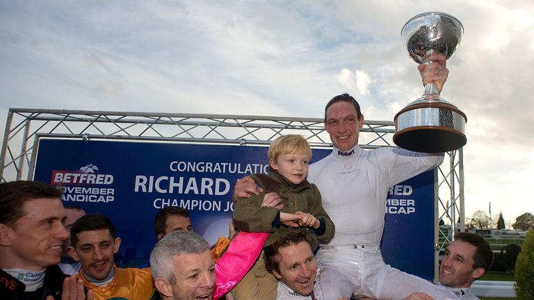 :  Richard Hughes celebrates winning the 2012 champion jockeys title with son Harvey at Doncaster racecourse