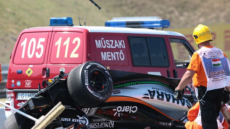 Sergio Perez's car lies upside down on the track