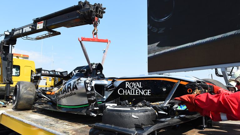 The crashed car of Sergio Perez is returned to the pits