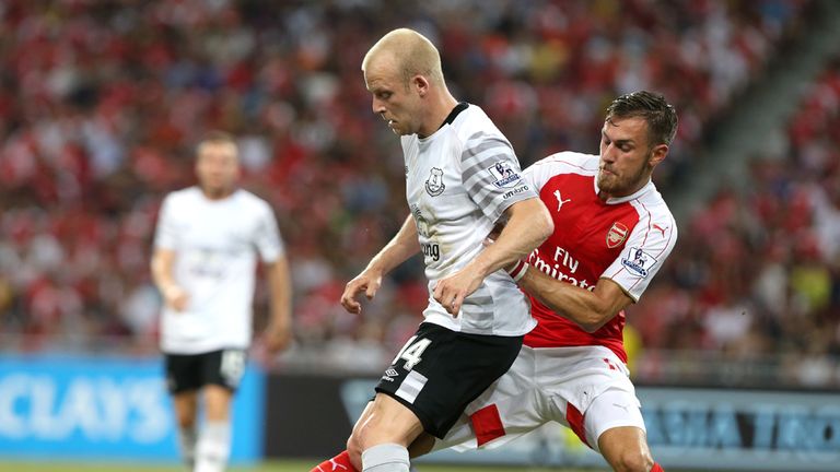 Steven Naismith is tackled by Aaron Ramsey 