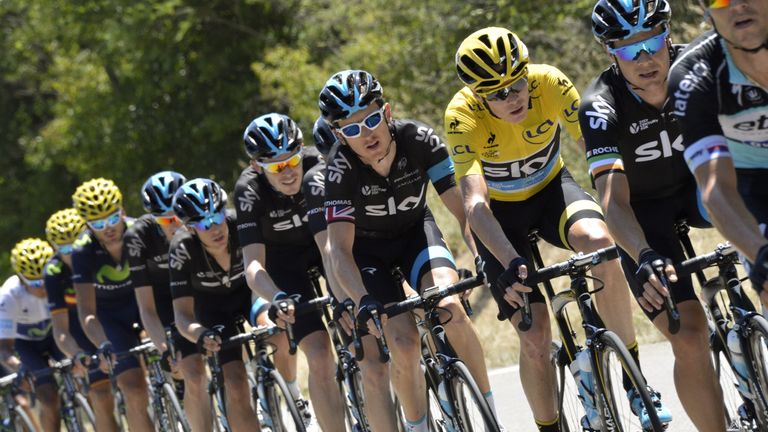 Christopher Froome (3rdR), wearing the overall leader's yellow jersey, rides in the pack with his teammates of the Great Britain's Sky cycling team