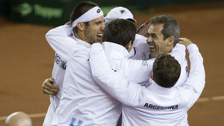 Argentina's Leonardo Mayer (top-L) celebrates with his teammate Carlos Berloq (hidden) and team captain Daniel Orsanic (R) their Davis Cup World Group win