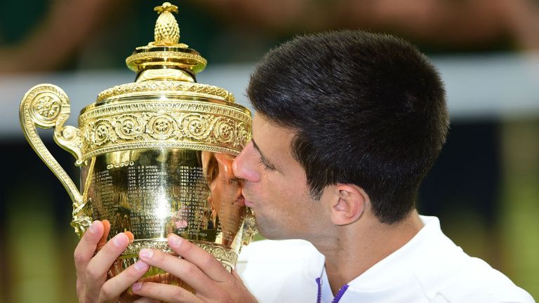 Novak Djokovic celebrates with the trophy after beating Roger Federer in 2015 Wimbledon final