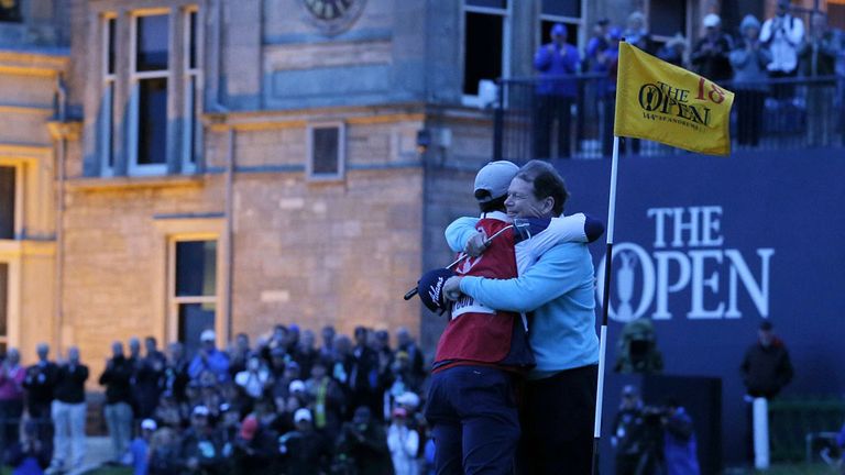In front of the clubhouse, US golfer Tom Watson (R) hugs his caddie, son Michael on the 18th green after his final round at the Open