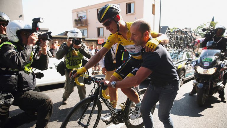Injured yellow jersey wearer Tony Martin of Germany and Etixx-Quick Step is given assistance after a fall close to the finish 