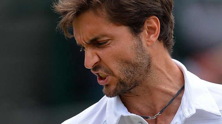 France's Gilles Simon reacts against Switzerland's Roger Federer during their men's quarter-finals match on day nine of the 2015 Wimbledon Championships 