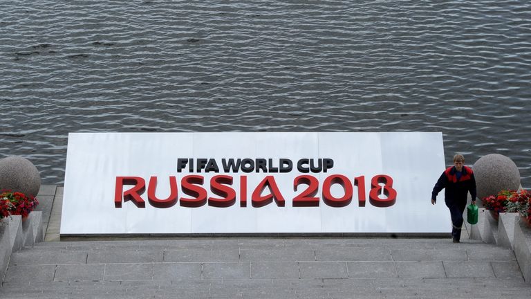A worker walks up stairs next to a banner promoting the Preliminary draw for the 2018 FIFA World Cup