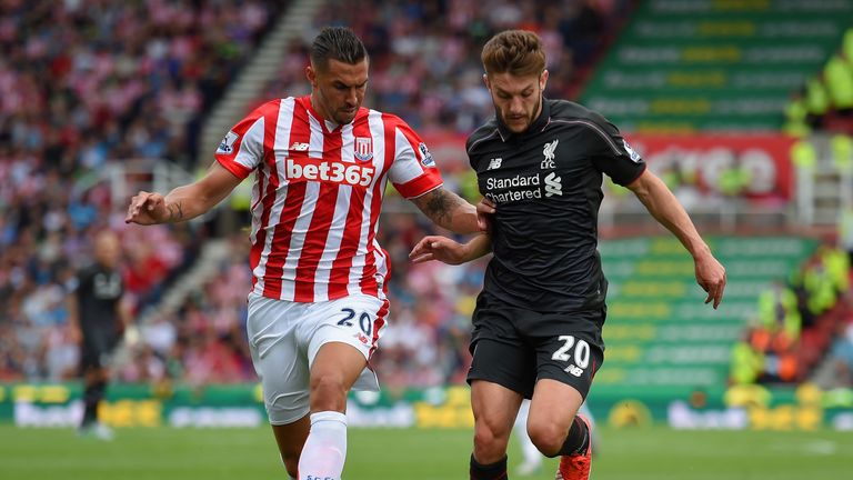Adam Lallana of Liverpool holds off Geoff Cameron of Stoke City