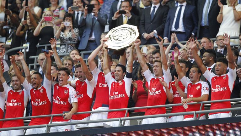Arsenal's Mikel Arteta (C) lifts the Community Shield trophy