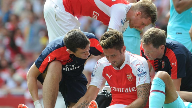 Olivier Giroud of Arsenal is treated by Gary O'Driscoll, Doctor, and Colin Lewin