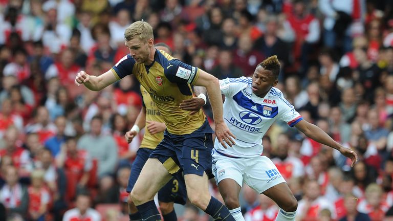 Per Mertesacker of Arsenal under pressure from Clinton N'Jie of Lyon during the recent Emirates Cup