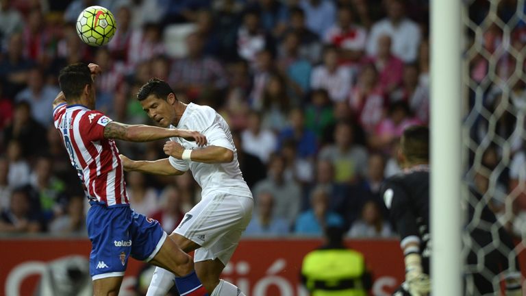 Cristiano Ronaldo (R) heads the ball during the Spanish league football match Sporting Gijon vs Real Madrid CF at the El Molinon stadium