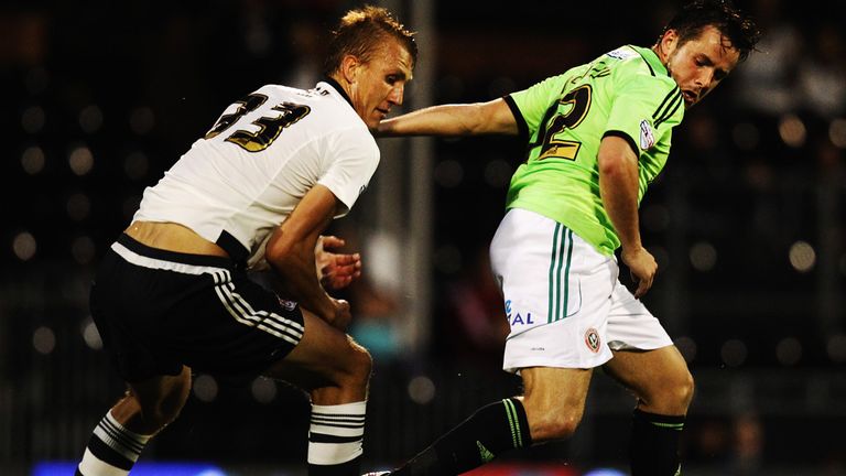 Dan Burn of Fulham and Marc McNulty of Sheffield United challenge for the ball 