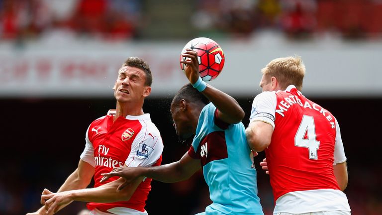 Diafra Sakho of West Ham United goes up for a header with Laurent Koscielny (L) and Per Mertesacker of Arsenal during the Premier League match