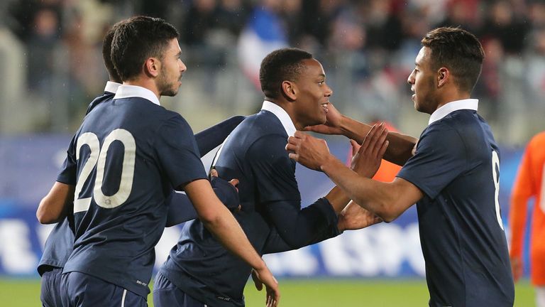 French players congratulate Anthony Martial (C) after he scored during a friendly U21 football match between France and the Netherlands